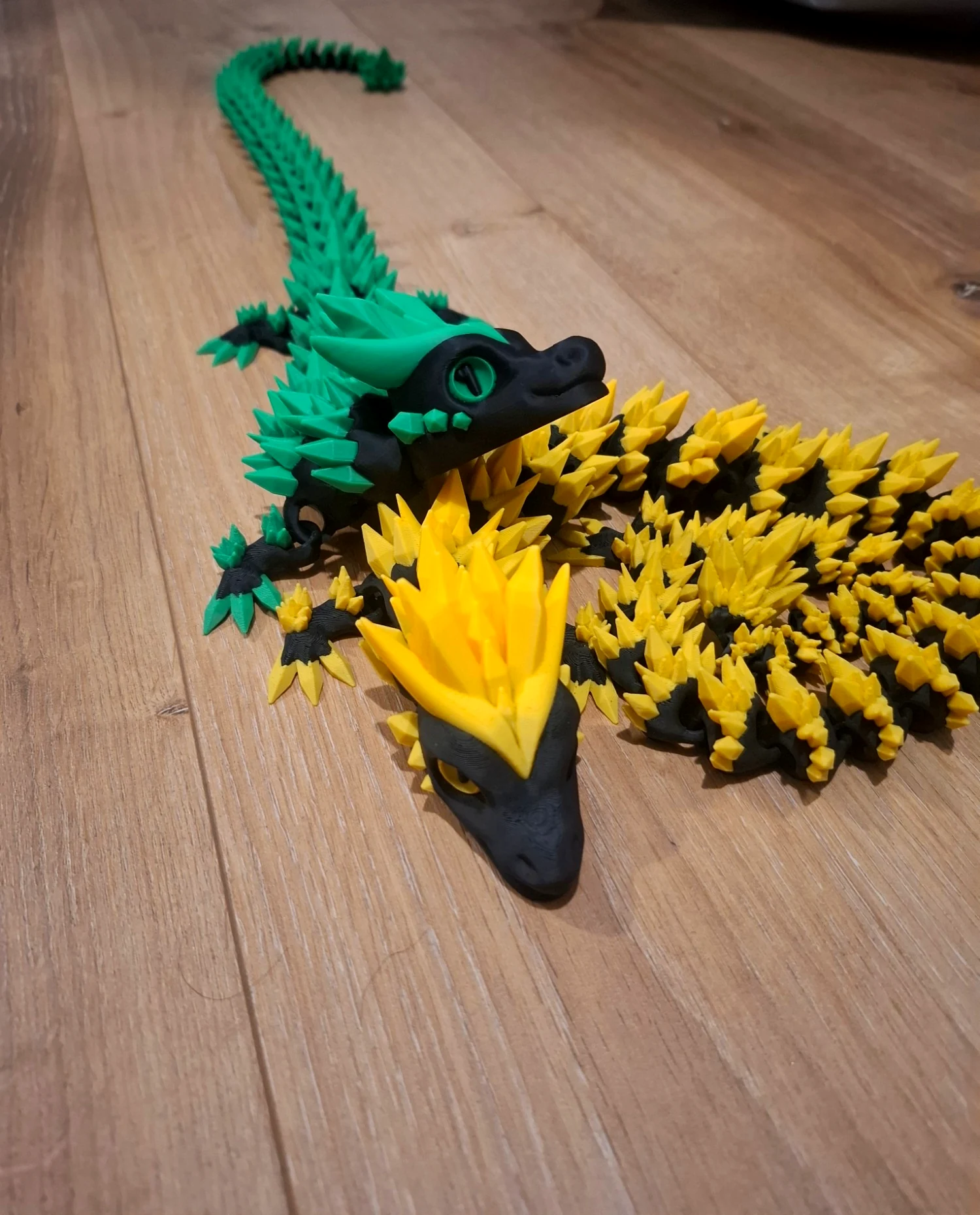 Deux dragons articulés imprimés en 3D, vert et jaune